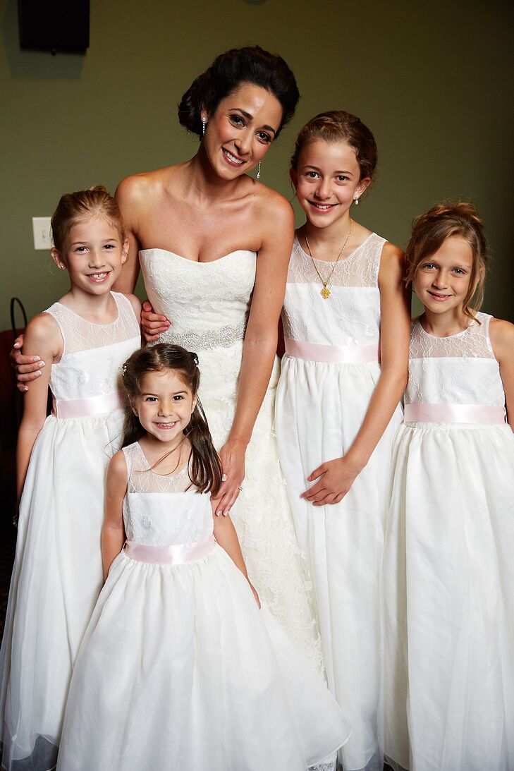 Maria had four flower girls for her traditional Greek Orthodox wedding. They wore white tulle-and-lace dresses to match Maria’s wedding dress. A soft satin blush belt completed their look with a subtle pop of color.