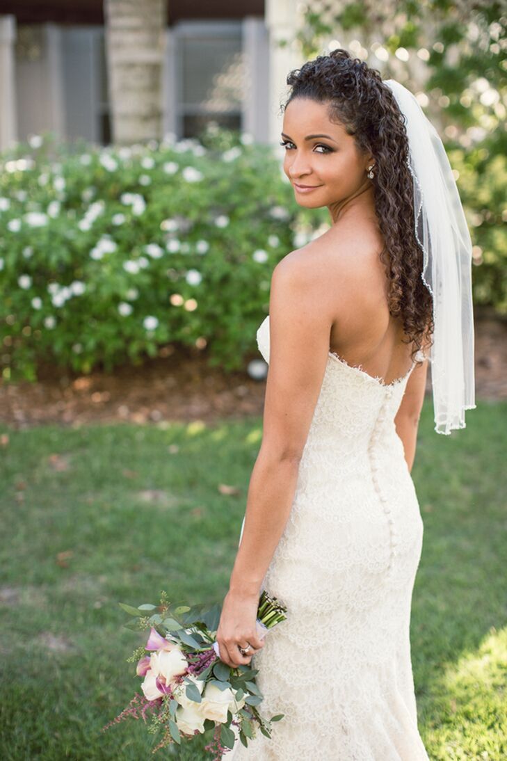 bride with brown curly hair wearing half-up style and simple one layer flyaway wedding veil