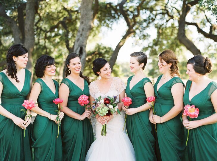 The bridesmaids wore deep green V-neck dresses, holding a single pink peony for a pop of color. "To capture the deep green of live oaks in the Texas Hill Country, the girls wore the same flowing dark green chiffon gowns we purchased from my hometown’s Bella Bridesmaid shop," Ann says. "The dresses went well with everyone’s skin tones and body types."