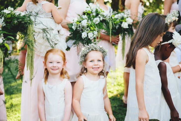 Two flower girls smiled at the camera, who wore ivory dresses and flower crowns. “We had 23 barefoot children walk down the aisle, all of who were either nephews, nieces or very close family friends,” says Anna. “Those too young to walk on their own were carried by their fathers.”