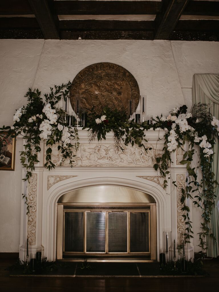 modern wedding fireplace mantel decor with white phalaenopsis orchids and greenery vines