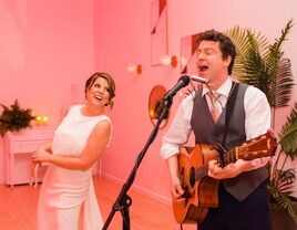couple performing with guitar at reception in Los Angeles, CA