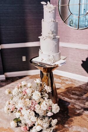 Four-Tier White Wedding Cake With Tall Layers, Gold Cake Stand and Floral Details