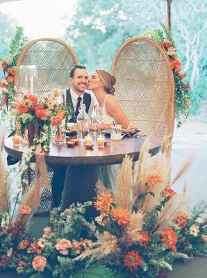 Couple in Rattan Sweetheart Table Chairs at The Greenhouse at Driftwood