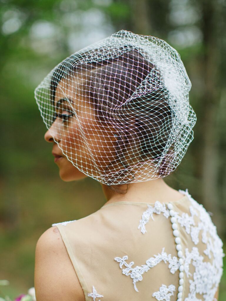 side hairstyles for wedding birdcage veil and low bun