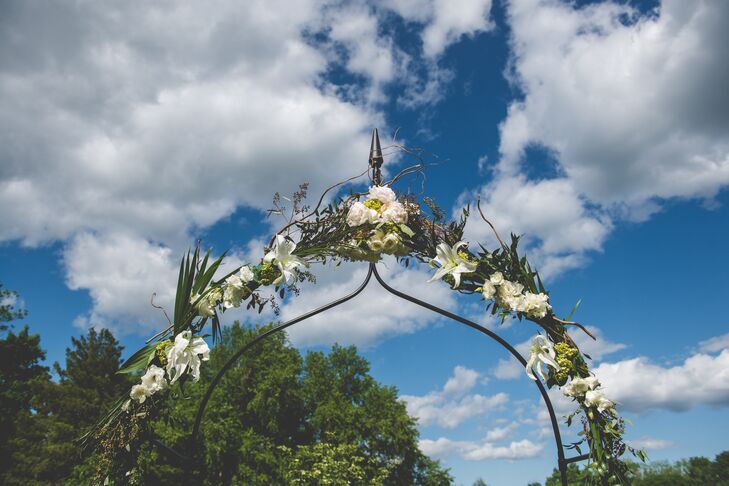 The wedding arch was decorated with white hydrangeas, white roses and white lilies for the spring reception.