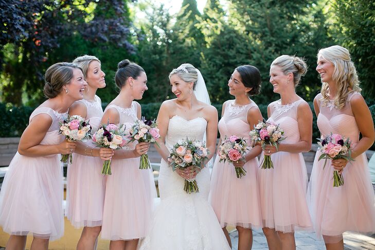 Mary's bridesmaids wore pink knee-length dresses by BHLDN with crystal embellished illusion necklines.
