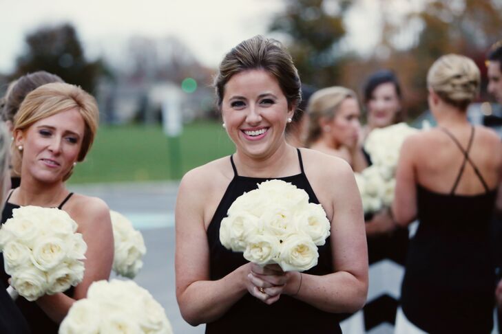 The bridesmaids carried simple bouquets of ivory garden roses with their black dresses. With their hair up in classic French twists, they accessorized simply with pearl stud earrings. This elegant look allowed their dresses to take center stage.