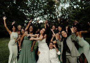 Bride Spraying Champagne With Wedding Party Members