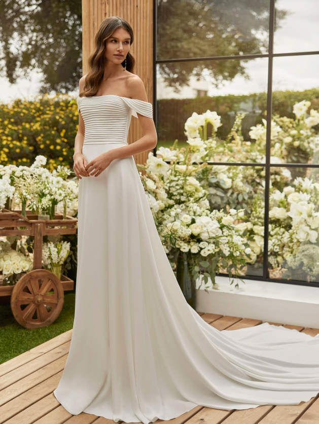 Model wears an elegant wedding dress by Spanish designer Rosa Clará.