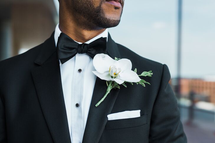 White Orchid Boutonniere Against Black Tuxedo