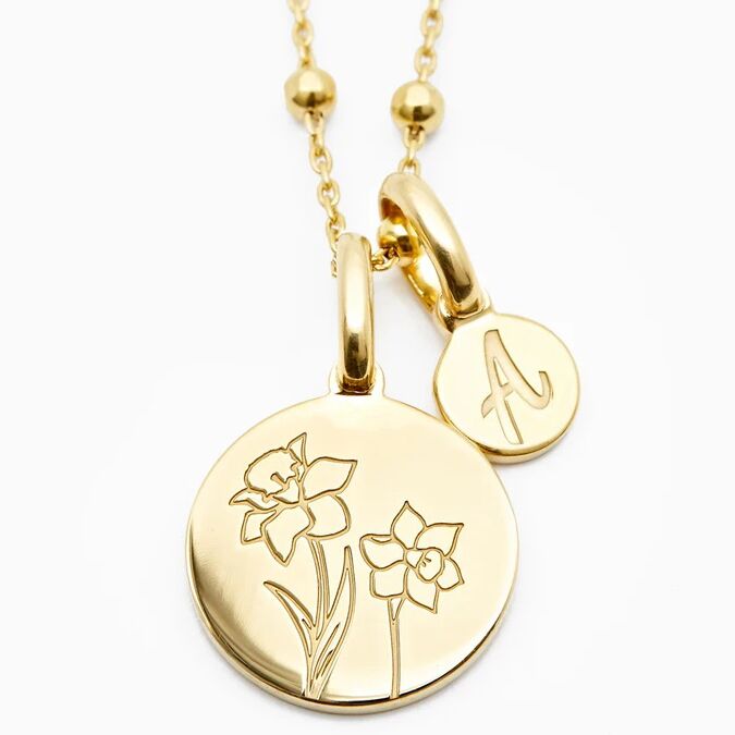 Gold disc necklace with daffodil imprint and small charm personalized with initial 10th anniversary gift