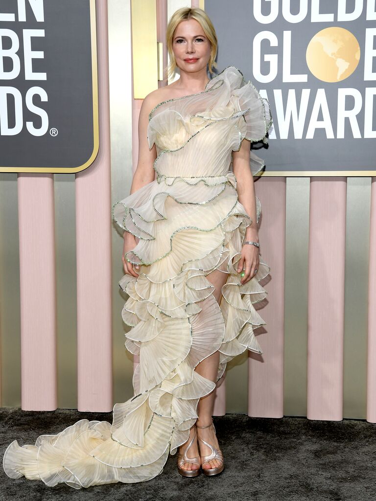Michelle Williams wears a ruffled dress on red carpet. 