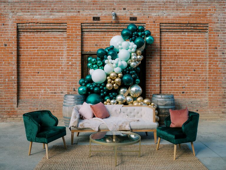 most popular wedding colors outdoor lounge area with green and gold balloon arch