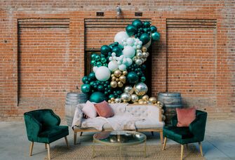 most popular wedding colors outdoor lounge area with green and gold balloon arch