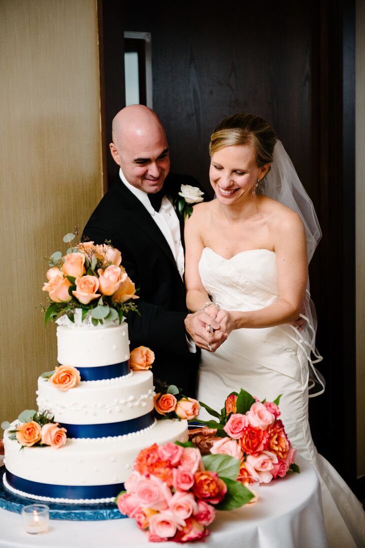 The couple's traditional wedding cake was given a cheerful touch with bunches of fresh coral roses dotting each tier.