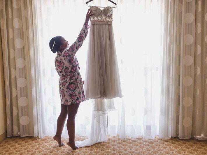 Bride with her wedding dress hanging up