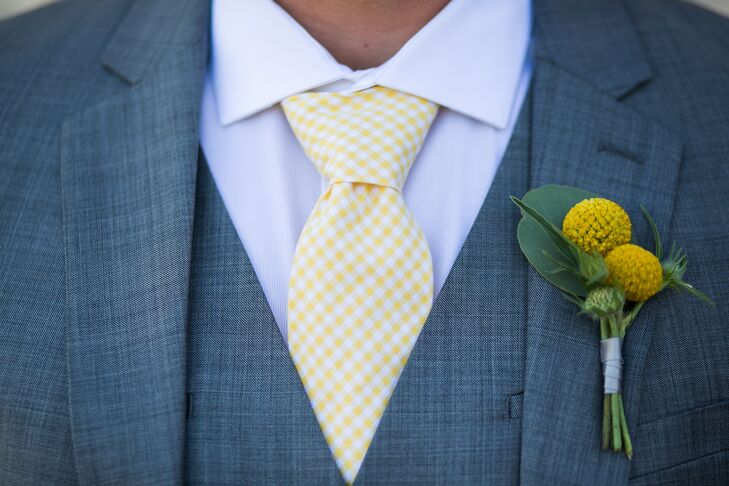 Drake pinned a yellow craspedia boutonniere to the lapel of his three-piece suit jacket, which he paired with a light yellow and white gingham tie. His wedding day look fit the yellow and gray color scheme at large.