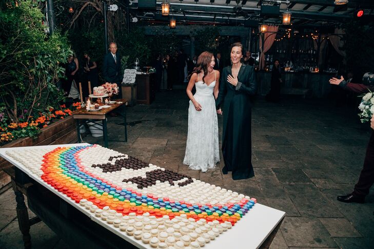 A display of rainbow-colored macaron desserts making a rainbow over two cats as a surprise to the two brides, representing the LGBTQ+ community and the brides' two pet cats at their romantic rooftop wedding in New York City at The McKittrick Hotel.