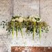 Wedding planner Martha Stilwell, from Details by Martha, worked her magic at the reception. She accented the head table with a textured champagne linen and a lush table runner. Wooden swings were suspended from the ceiling above the table. They were topped with hanging amaranthus, eucalyptus, hydrangeas, roses and hypericum.