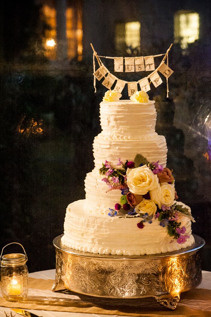 In addition to providing dinner, Jamie Hollander Catering also created an amazing white wedding cake for the reception. The raspberry and sea salt caramel cake was covered in vanilla icing and decorated with cascading roses and wildflowers.
