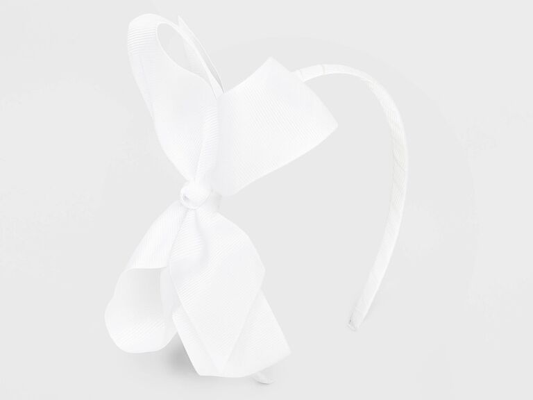 White headband with a large bow. 