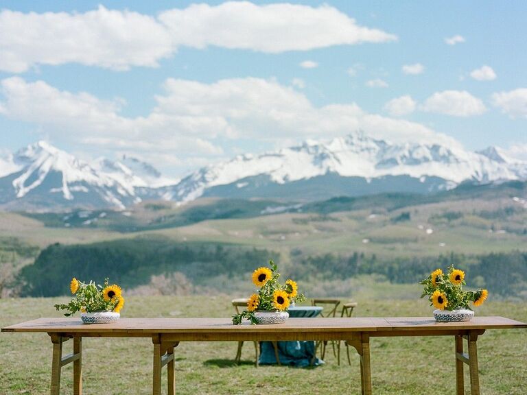 Table with sunflower centerpieces overlooking mountains