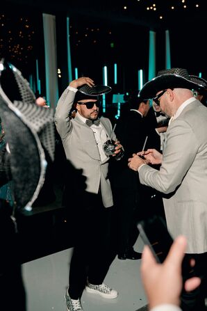 Grooms Dancing With Festive Cowboy Hats During Reception