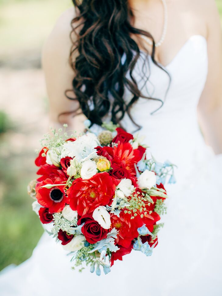 Red anemones, peonies and white mums mixed together with queen anne's lace and a few blue accents in the vibrant bridal bouquet.