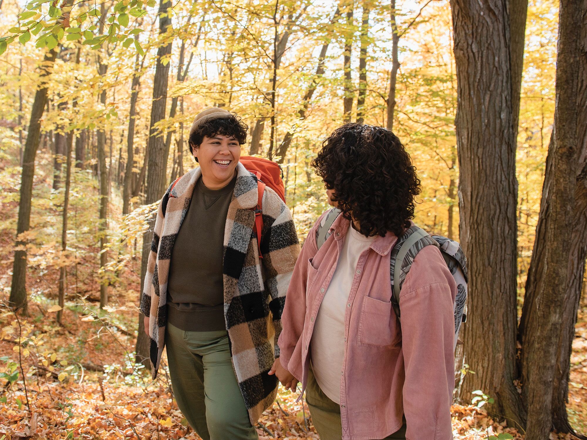 Couple in love hiking in wood for Thanksgiving proposal