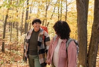 Couple in love hiking in wood for Thanksgiving proposal