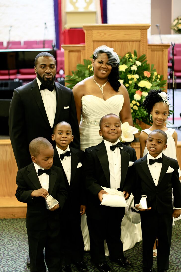 The couple stood with their flower girl and ring bearers in  front of where their ceremony took place at Mt. Zion Fellowship in Highland Hills, Ohio.