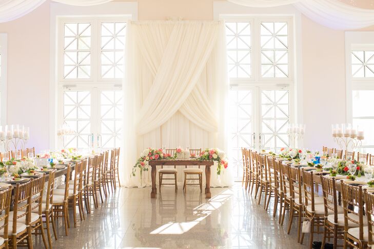The interior of Namar Event Center in South Padre Island, Texas, was just as impressive as the outside: It had elegant ivory drapery and oversize windows that let in lots of natural light. Rustic family-style dining tables and chiavari chairs enhanced the elegant beachy atmosphere.