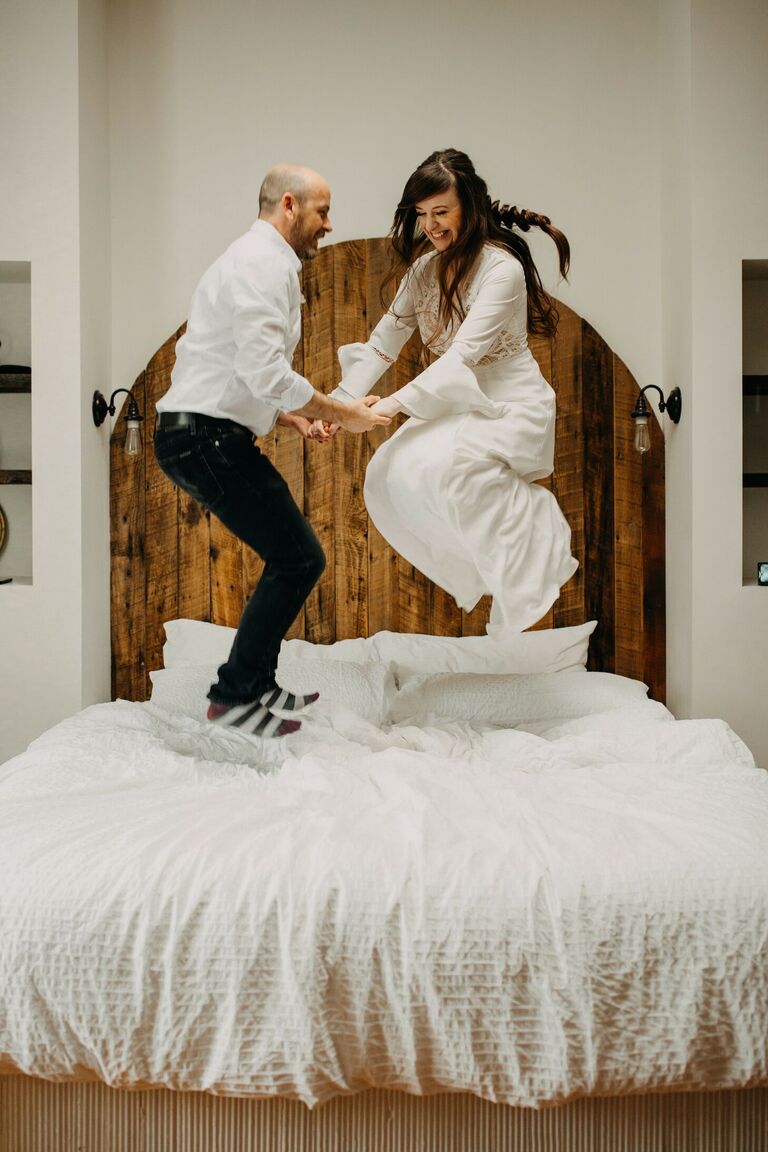 Couple jumping on bed