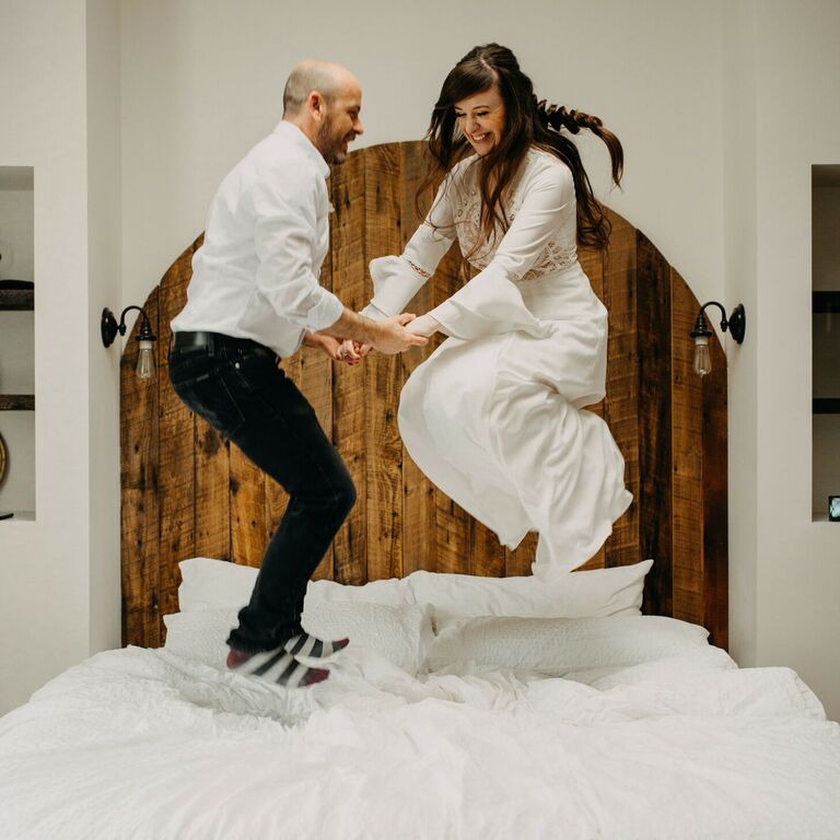 Couple jumping on bed