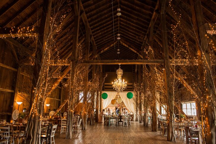 The ceremony was held at the barn at Friedman Farms. Fairy lights and chandeliers were strung from the rafters. The head table was demarcated by giant balloons.