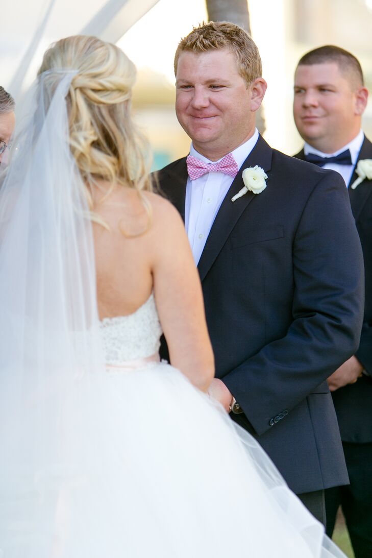 Andy picked out just the right accessories for his bold look. A preppy pink bow tie wrapped around the collar of his white shirt and brought in their palette. This matching white ranunculus boutonniere also accented his lapel.