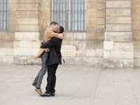 two men smile and embrace as a couple
