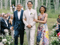 mother of groom walking son down aisle in floral dress