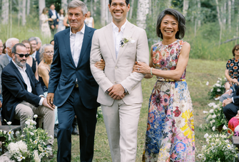 mother of groom walking son down aisle in floral dress