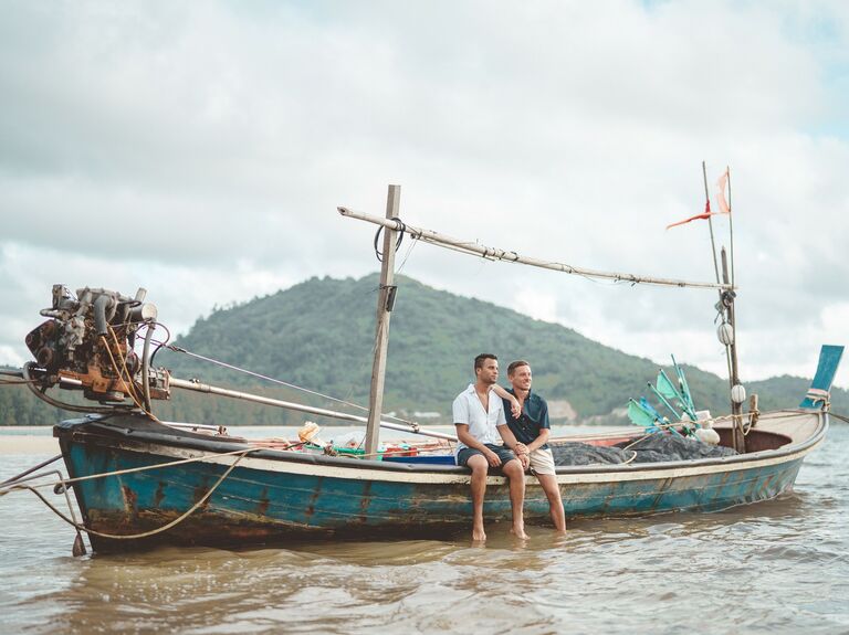 Couple sits on a long boat in Thailand. 