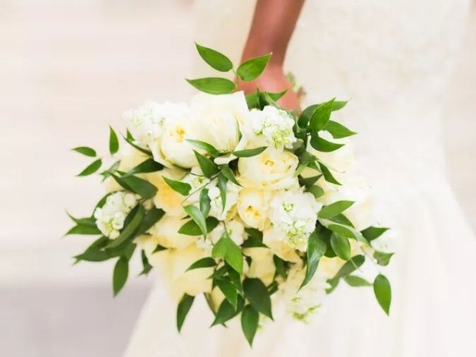 Bride holding bouquet with Ruscus and roses