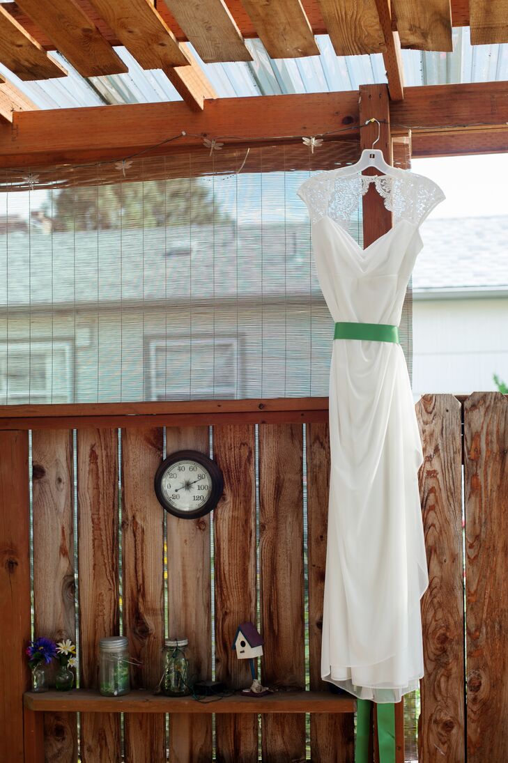 Melissa wore a simple ivory wedding dress with lace accenting the sleeves, opening up into a keyhole design on the back. She had a bright green ribbon sash wrapped around her waist, adding a touch of color to the wedding day attire.
