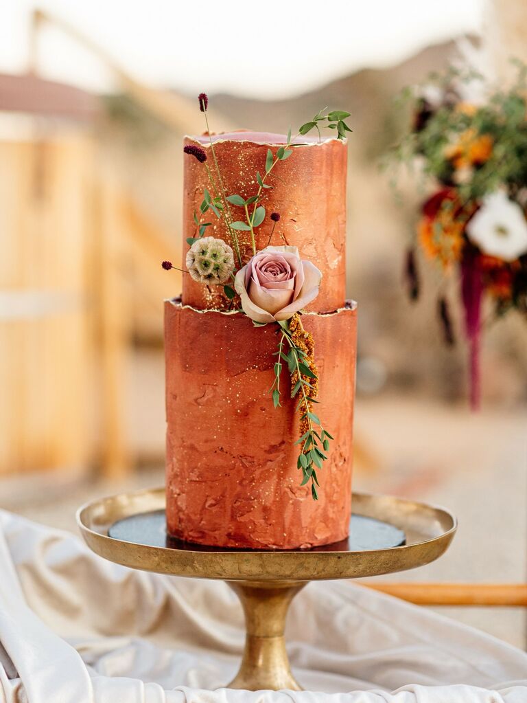 Rust colored wedding shower cake decorated with fresh flowers. 