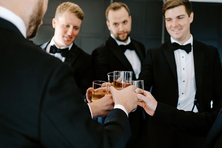 Groom and Groomsmen in Classic Tuxedos Toasting With Whiskey Drinks