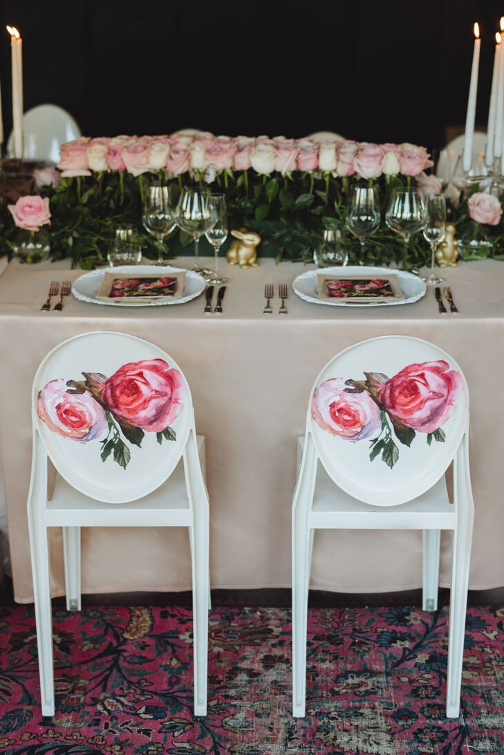 The modern round-backed chairs from the ceremony were repurposed for the reception, where their vibrant pink rose decals worked to transform the rooftop event space into a whimsical garden-like scene. Paired with details such as a lush green garland and bountiful blush blooms, the chairs brought the couple’s romantic vision to life.