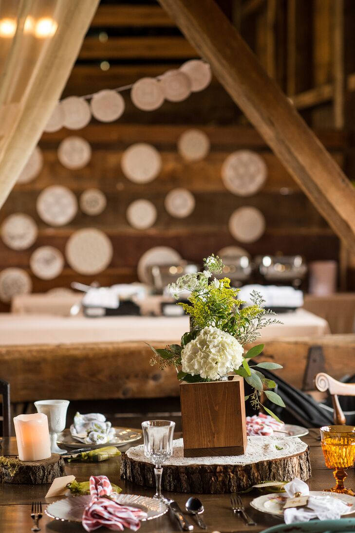 T.C. made the wooden centerpieces, which featured white lisianthus and Queen Anne's lace, and their tree trunk stands. Gabrielle's lace doilies create a whimsical backdrop to the DIY reception.