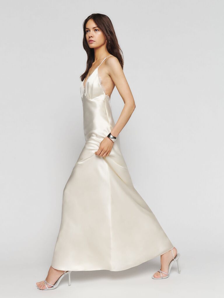 A silk strappy maxi dress with a plunge v neckline lined with lace in cream from Reformation