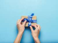 Wedding guest wrapping gift with blue bow