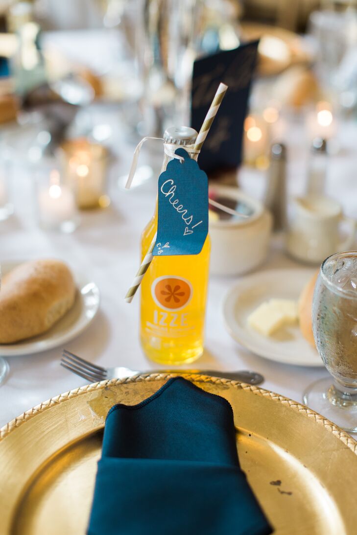 While most place settings were accented with sparkling wine wedding favors, Brianna and Eric had a nonalcoholic option. Some friends and family members took home Izze sparkling  juice with a gold-striped straw as their wedding favor.